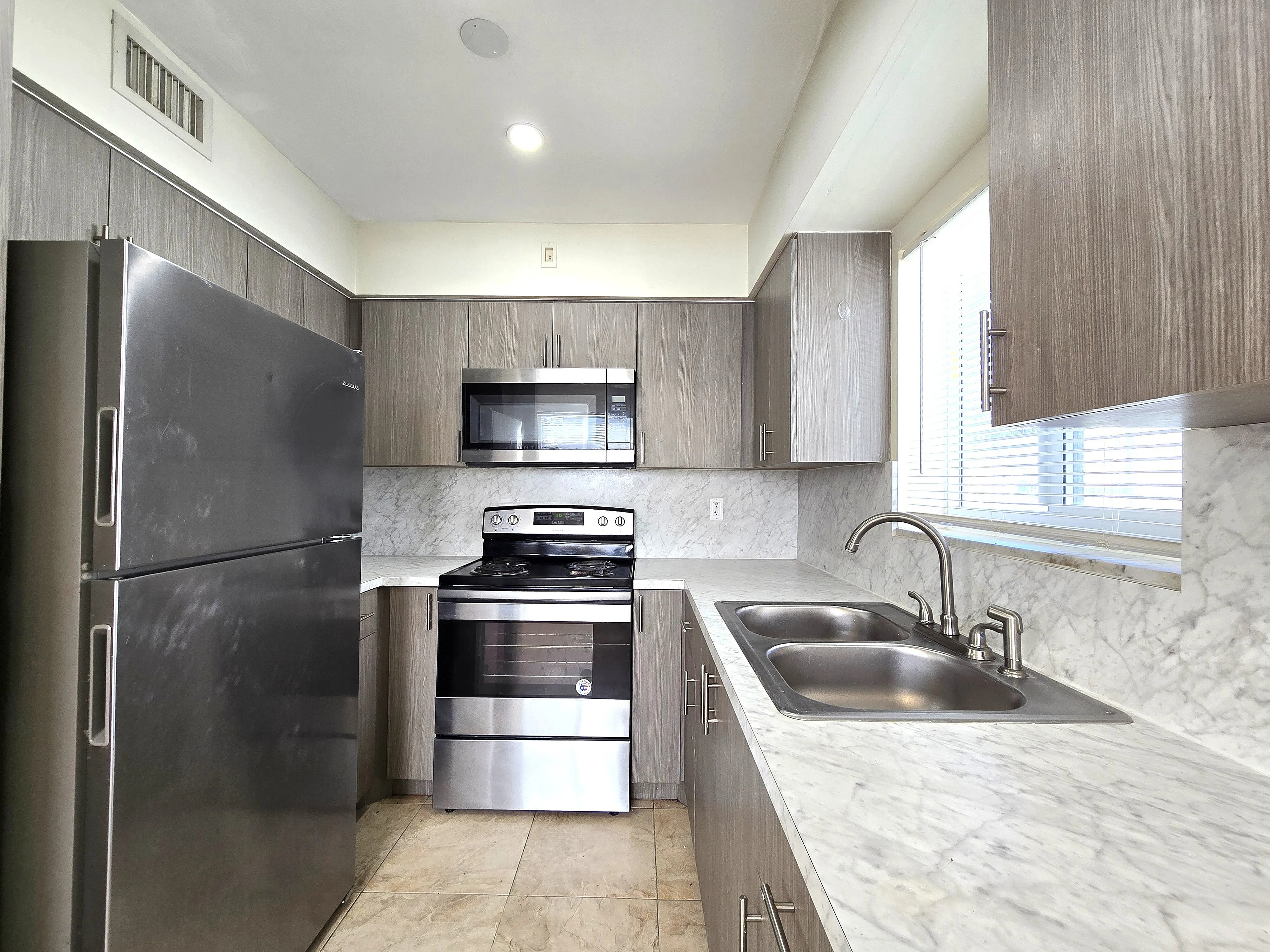Modern kitchen with sleek stainless steel appliances, elegant countertops, and ample natural light.