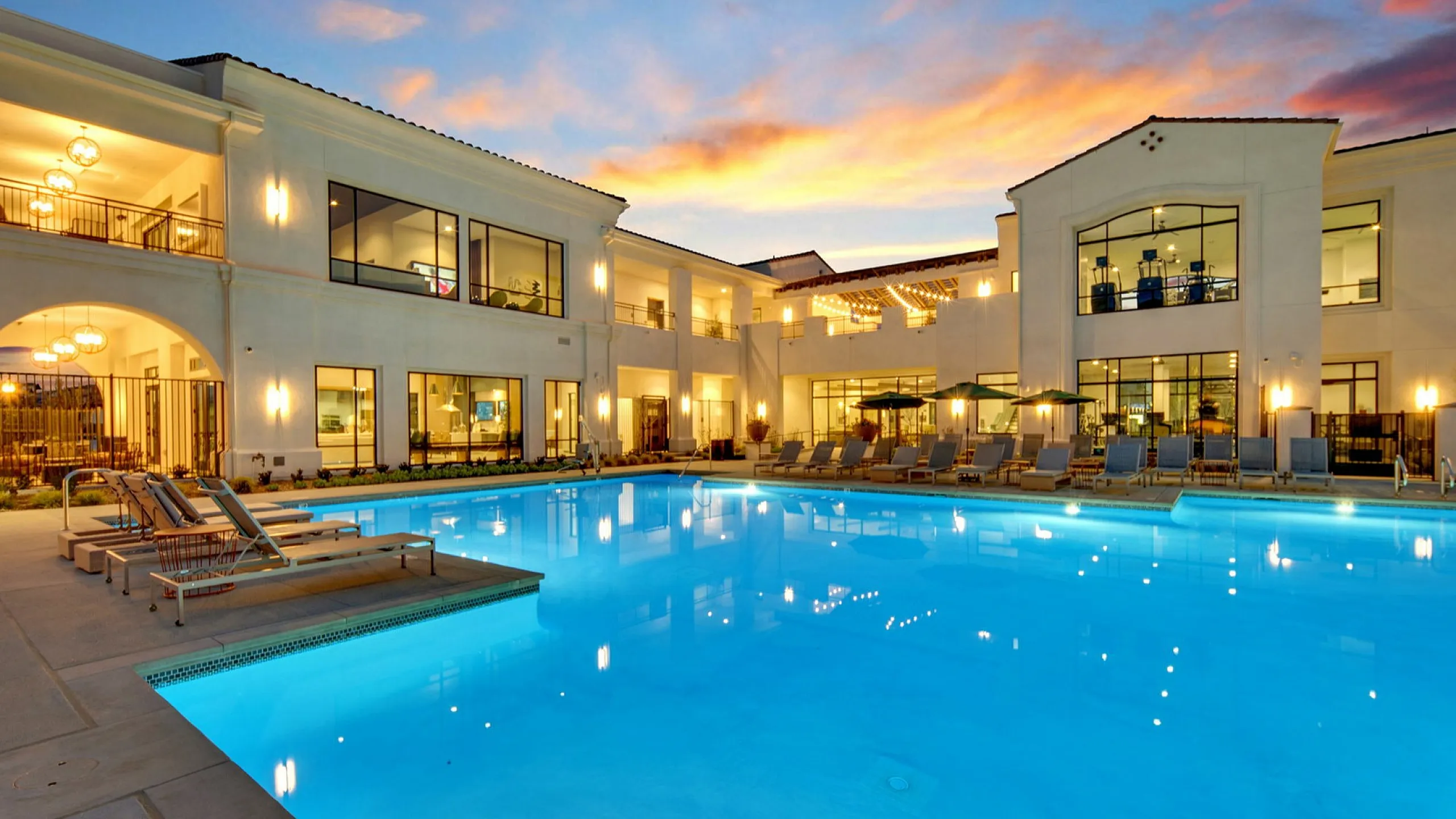 Enclave Heritage Flats community pool with a sunset in the background