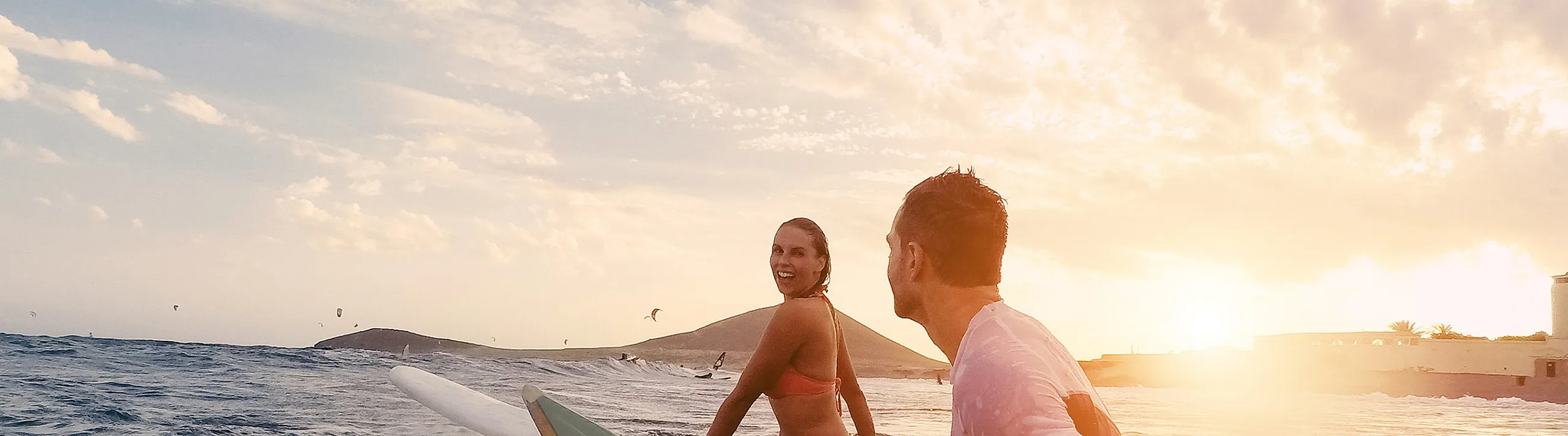 Joyful surfers immersed in a picturesque ocean sunset, capturing the essence of adventure and relaxation.