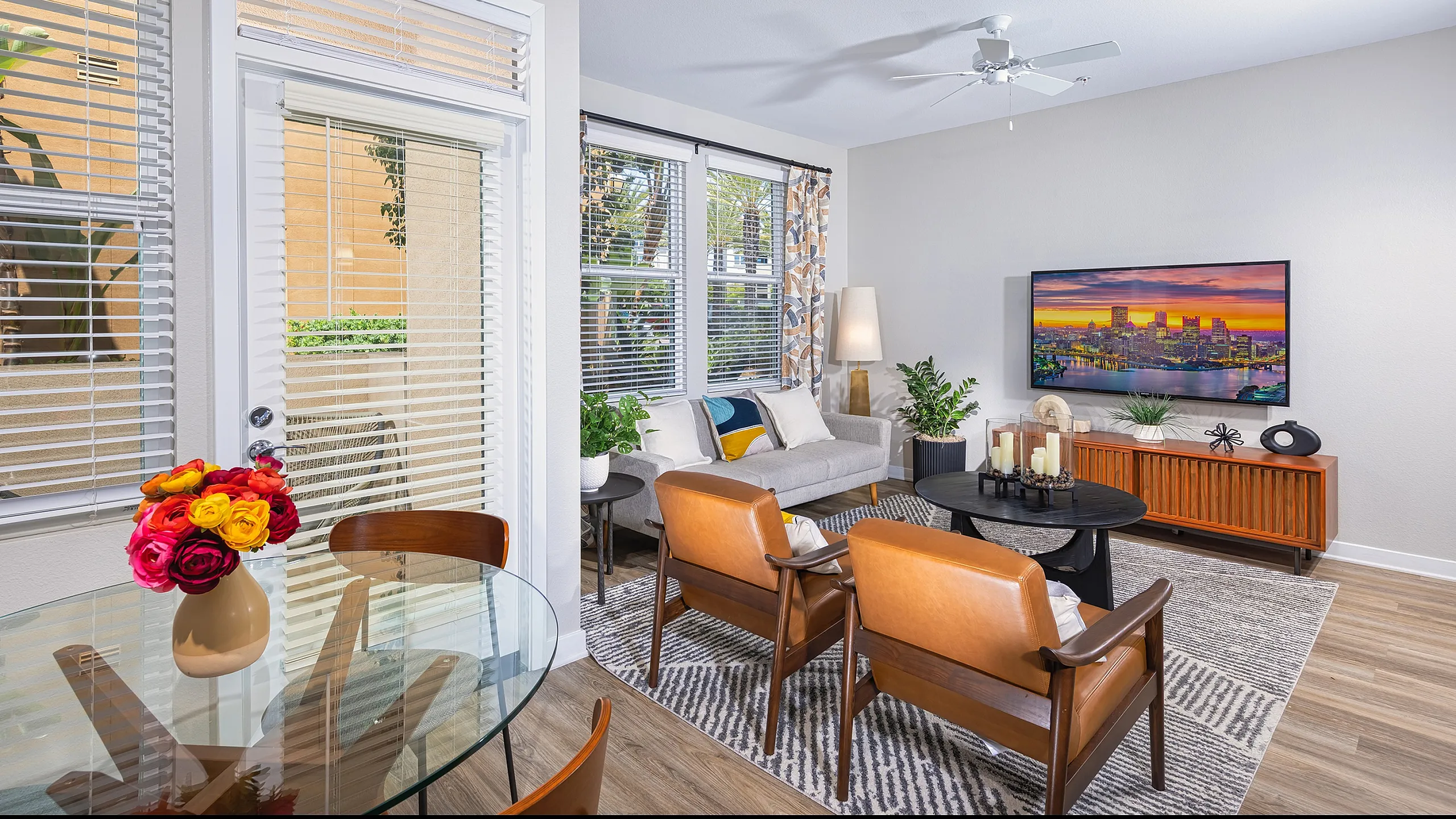 Bright and inviting living room with modern decor, featuring large windows, a cozy sofa, and stylish furniture arrangements, perfect for relaxation and entertaining.