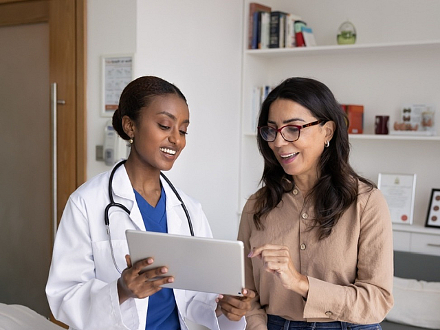 Friendly healthcare provider discussing with a patient in a modern clinic, showcasing patient-centered care.
