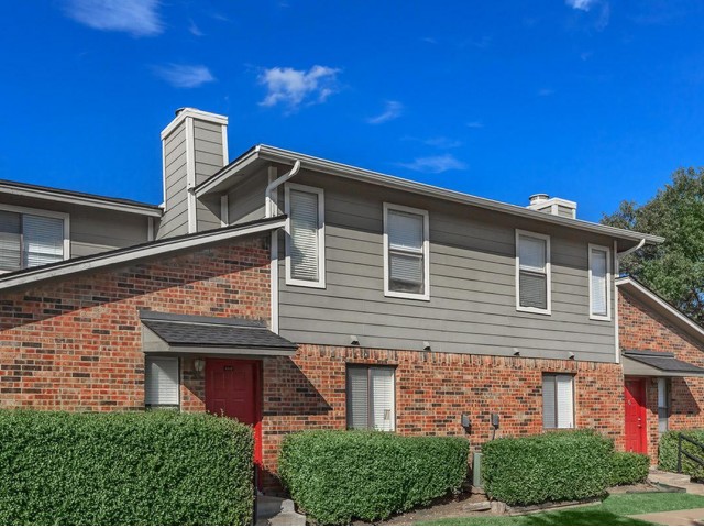 Exterior red brick with gray paneling and green landscaping