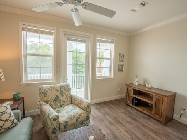 Furnished sitting area with ceiling fan in resident lounge facing back porch