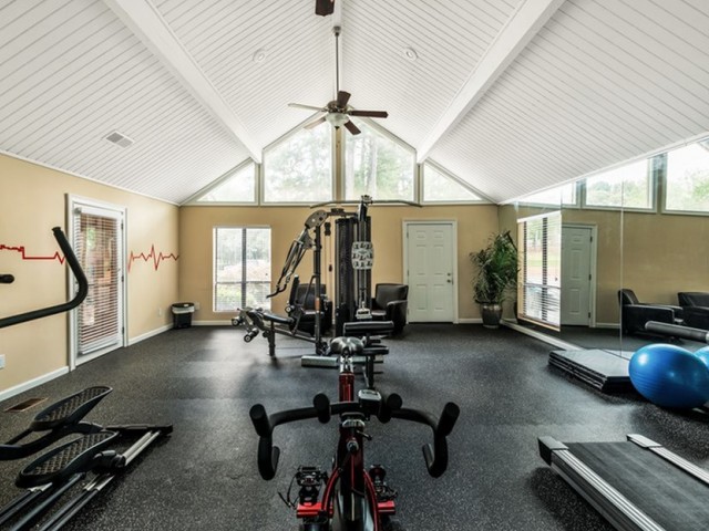 fitness center with a treadmill, stationary bike, elliptical, and universal weight machine