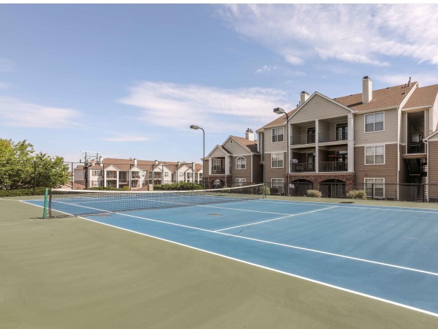 tennis court with apartments behind