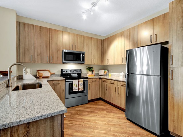 400 north apartments Maitland Florida kitchen with stainless appliances, wood cabinets and flooring and granite counters