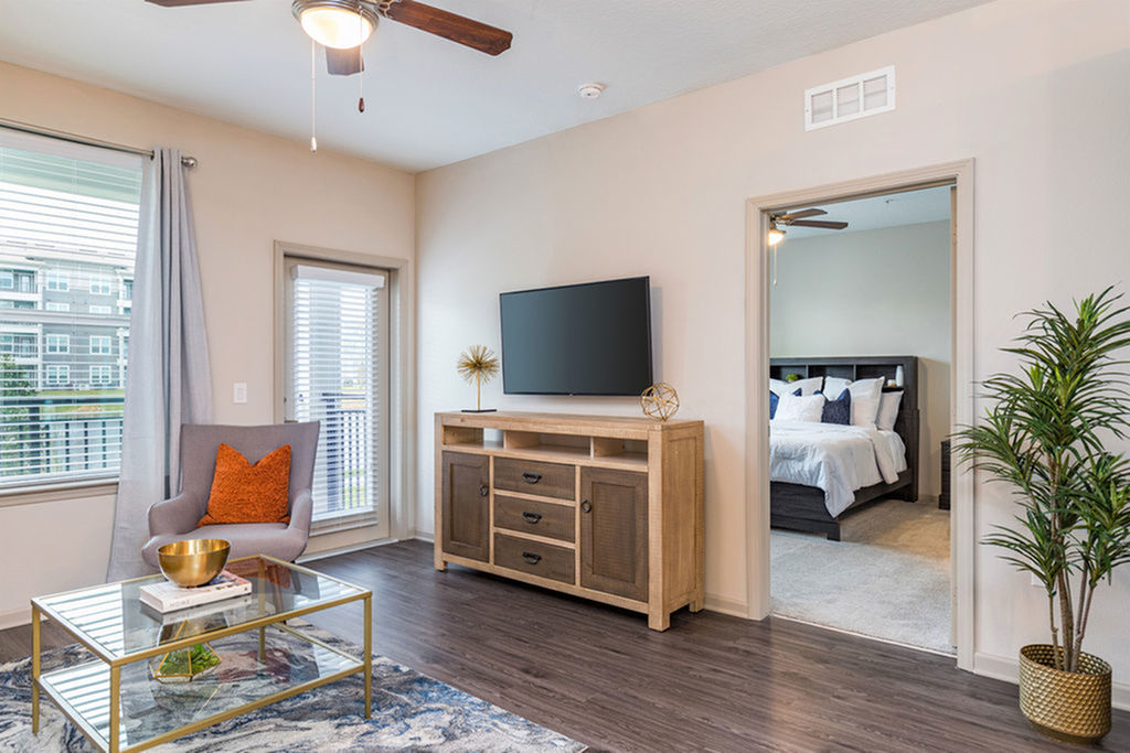 San Mateo Apartments Kissimmee Florida living room with vinyl plank flooring, french patio door, and ceiling fan