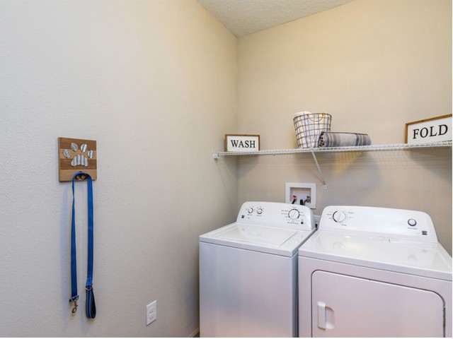 San Mateo Apartments Kissimmee Florida laundry room with full size washer and dryer and storage rack above appliances