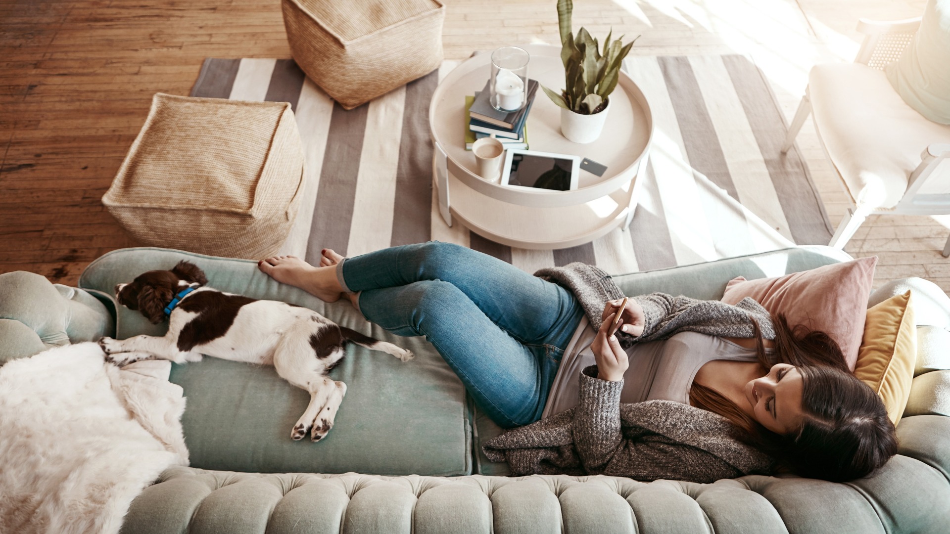 Woman laying on couch with a dog