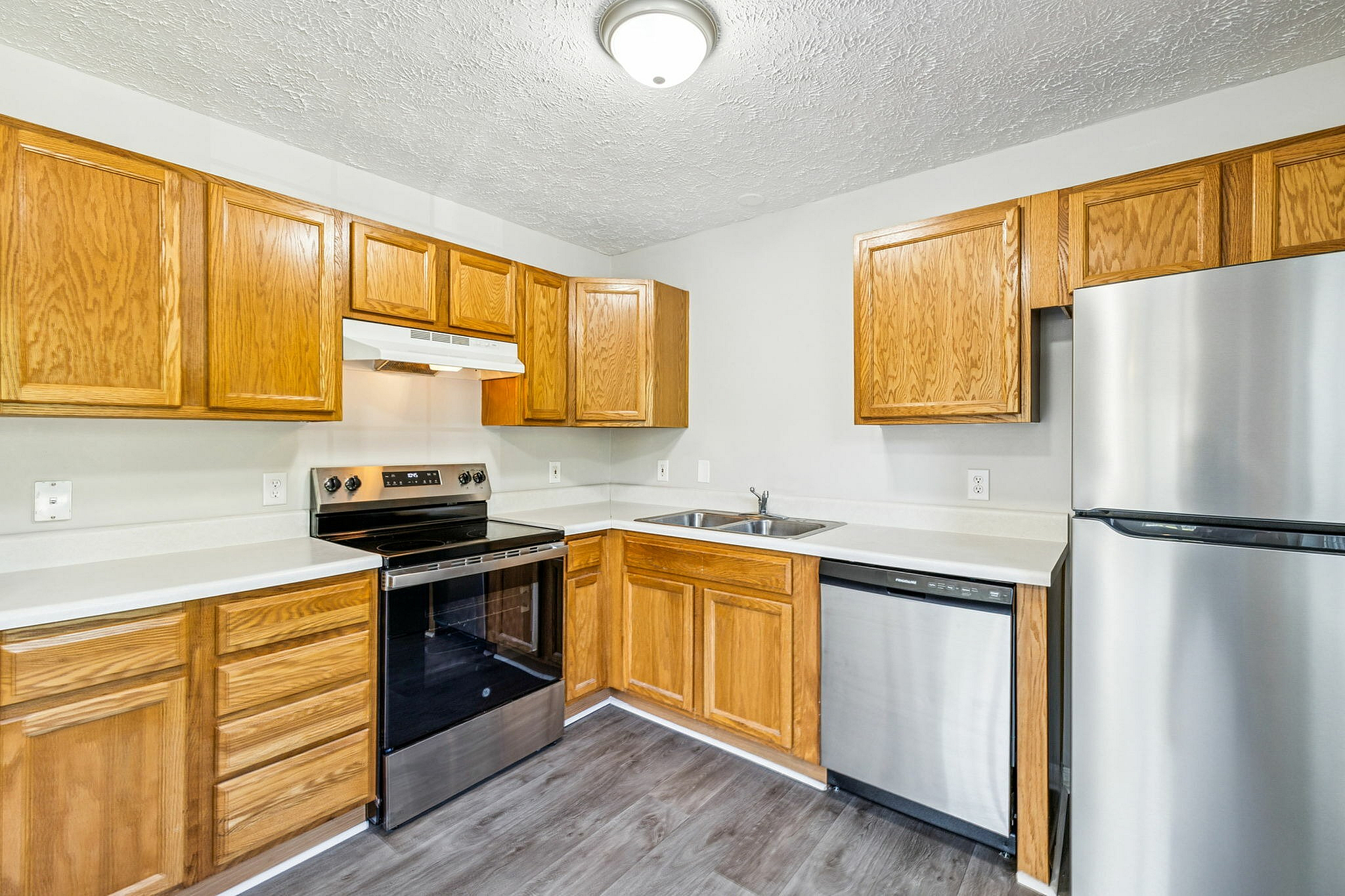 Modern kitchen with stainless steel appliances, sleek countertops, and abundant wooden cabinetry for ample storage.