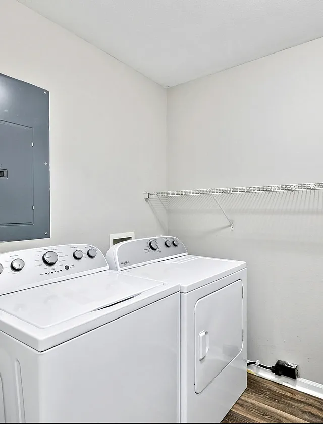 Modern laundry room with sleek washer and dryer set, featuring a clean design and organized shelving in a bright space.