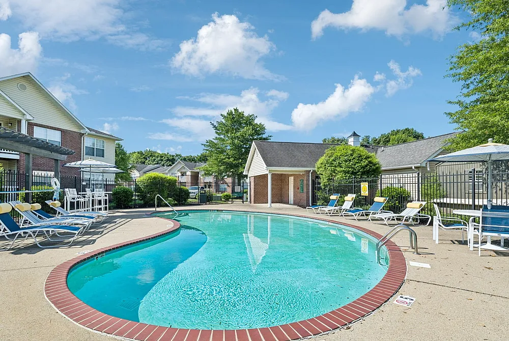 Inviting outdoor pool area with comfortable lounge chairs and vibrant greenery, perfect for relaxation and leisure.