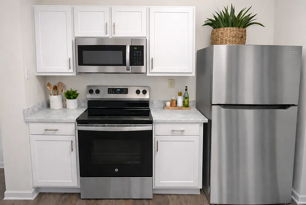 Modern kitchen with stainless steel appliances, sleek white cabinets, and elegant marble countertops.