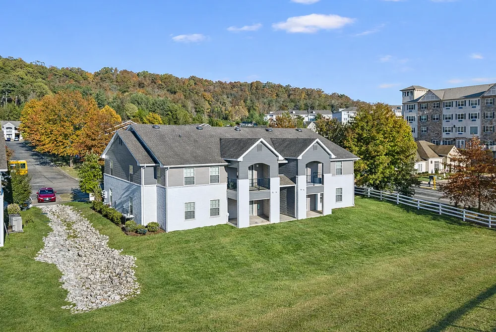Charming suburban apartment complex surrounded by lush greenery and autumn foliage, offering a tranquil and picturesque living environment.