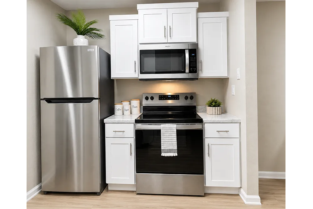 Modern kitchen with sleek stainless steel appliances, elegant white cabinetry, and stylish countertop decor.