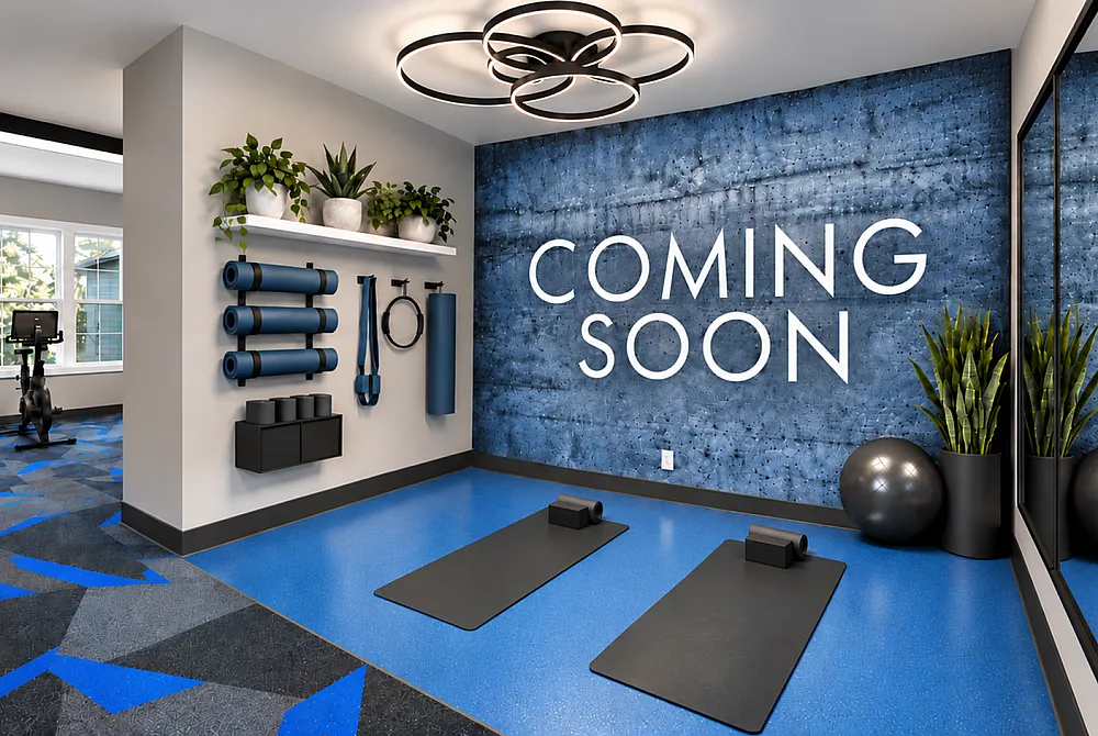 Modern fitness corner with yoga mats, exercise equipment, and stylish decor, featuring a 'Coming Soon' announcement on a chic blue accent wall.