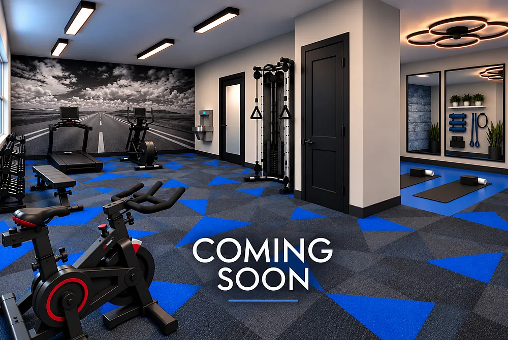Elegant modern gym with state-of-the-art equipment, vibrant blue geometric flooring, and scenic wall mural. Coming soon.