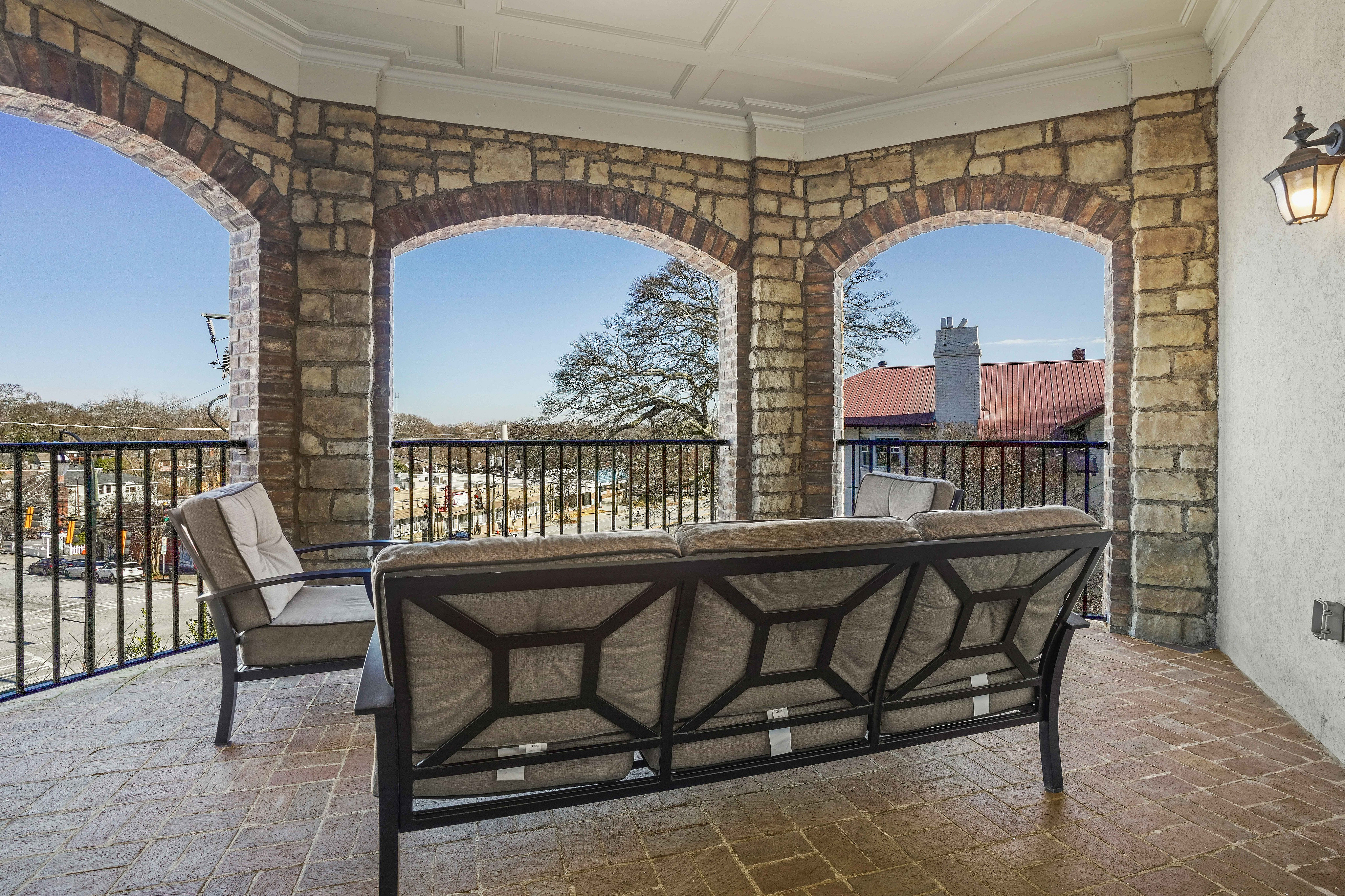 Charming stone terrace with cozy seating and scenic city views, perfect for relaxation and social gatherings.
