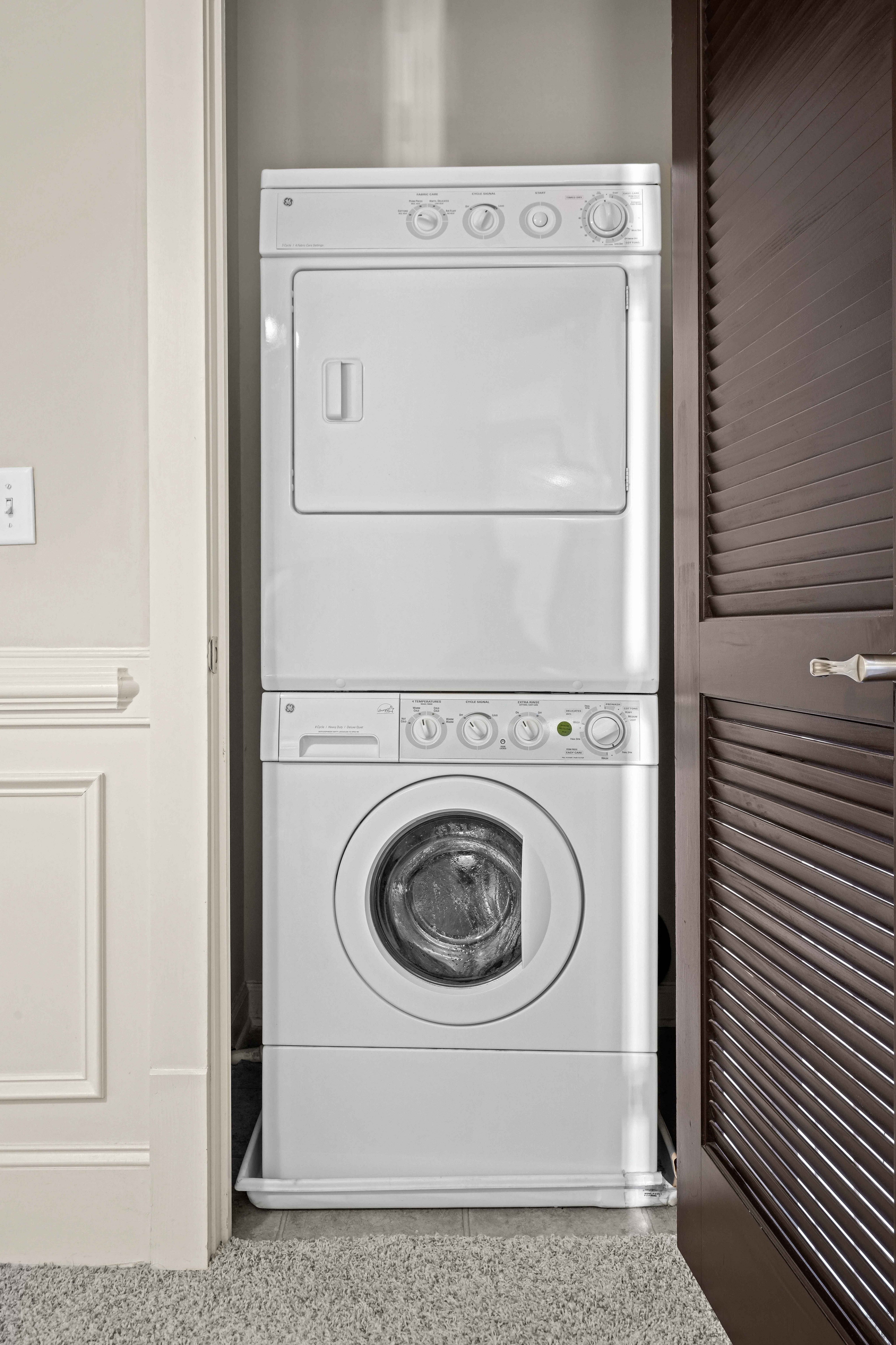 Convenient in-unit stacked washer and dryer in a modern apartment closet, offering efficient use of space.