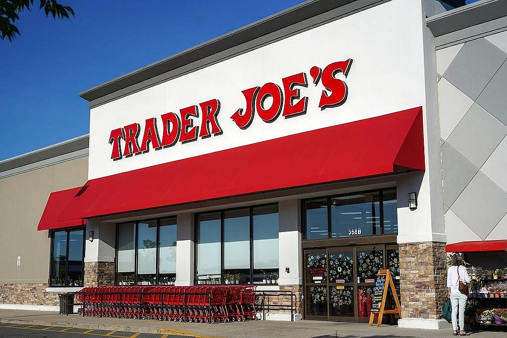 Inviting Trader Joe's store entrance with a vibrant red awning and neatly arranged shopping carts, creating a friendly shopping atmosphere.