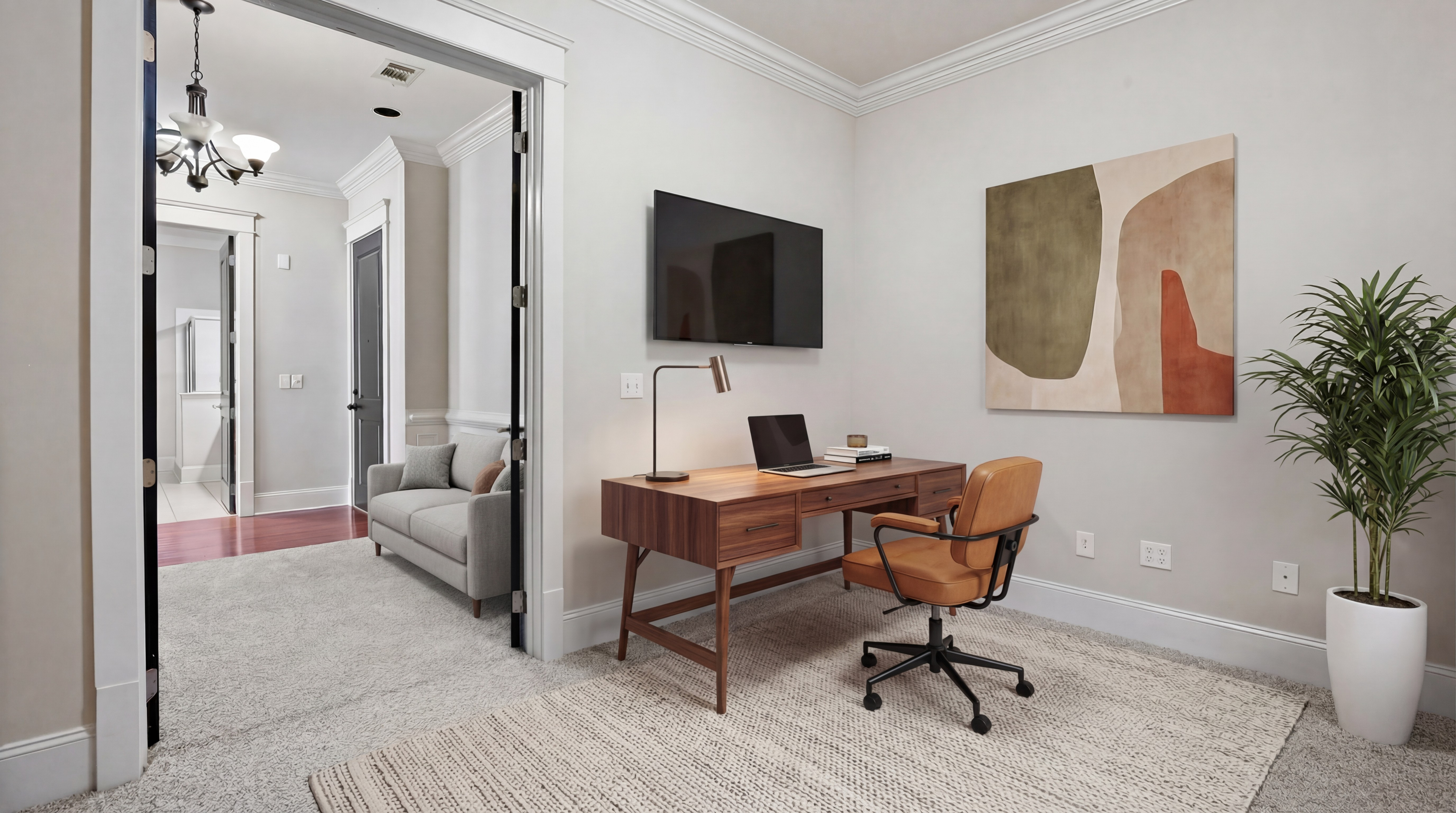 Chic home office featuring a sleek wooden desk, modern art piece, and comfortable seating with natural light.