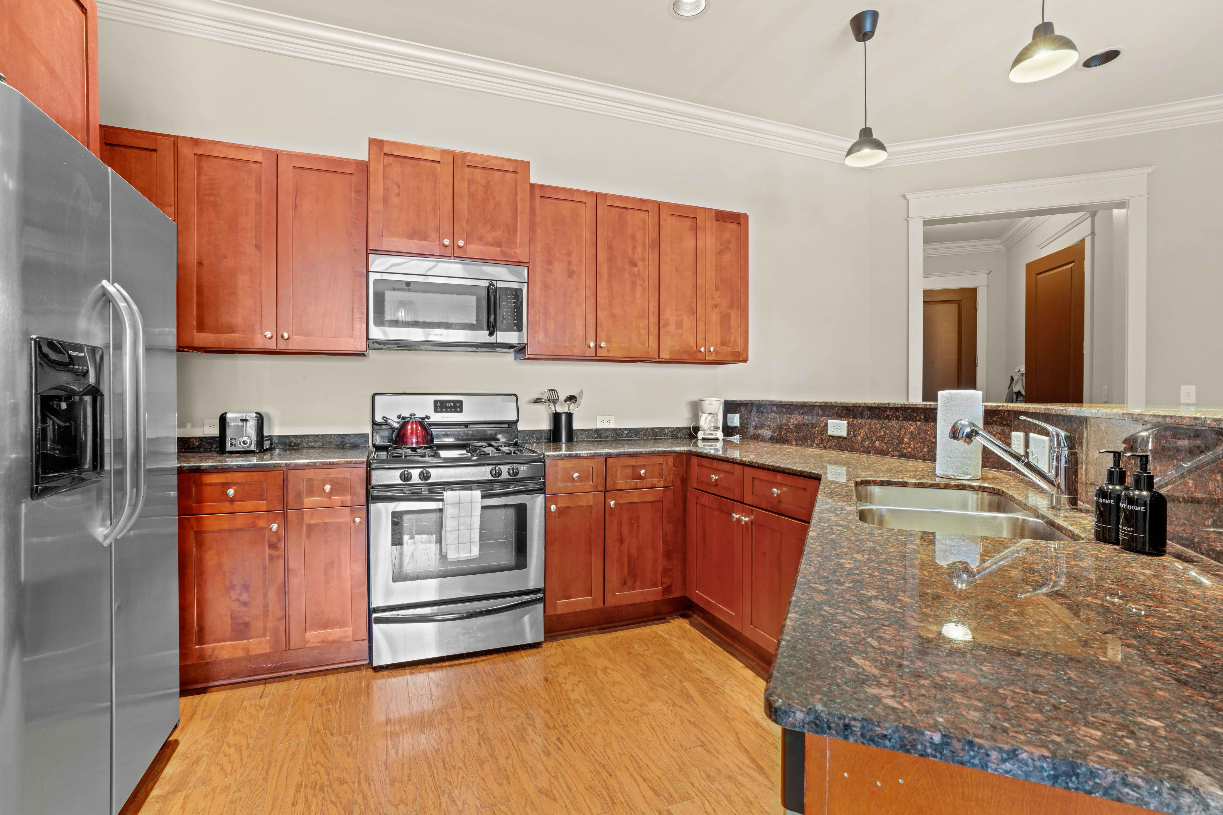 Modern kitchen with elegant wooden cabinetry, stainless steel appliances, and a stylish granite countertop.