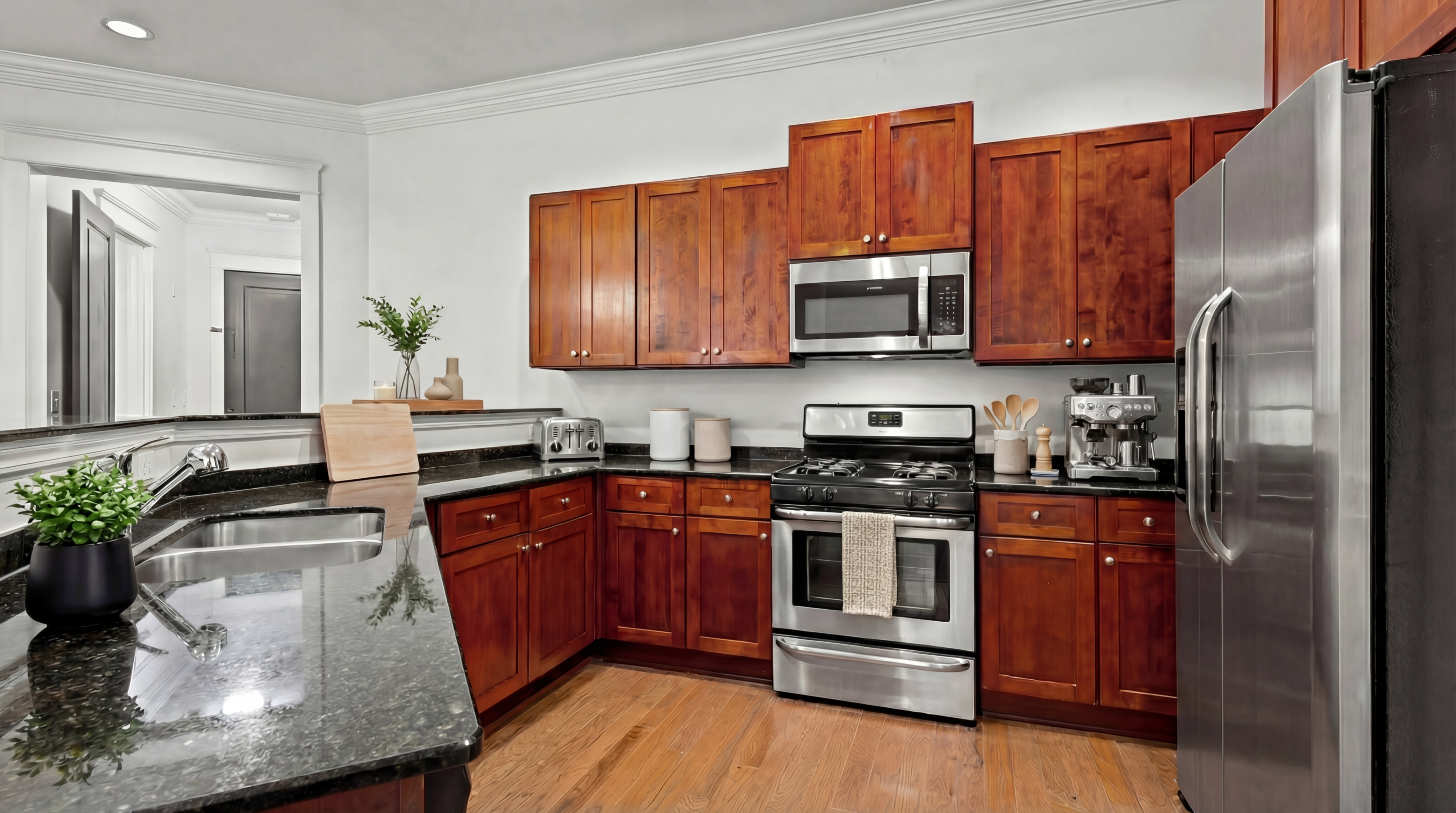 Modern kitchen with sleek stainless steel appliances, rich wooden cabinets, and elegant granite countertops.