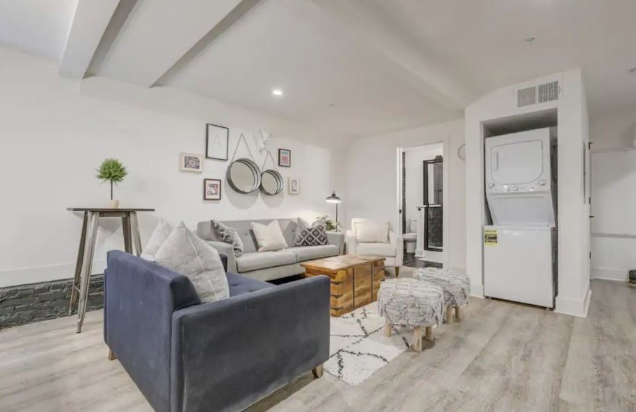 Inviting modern living room with stylish decor, cozy seating, and convenient in-unit laundry in a bright, open space.