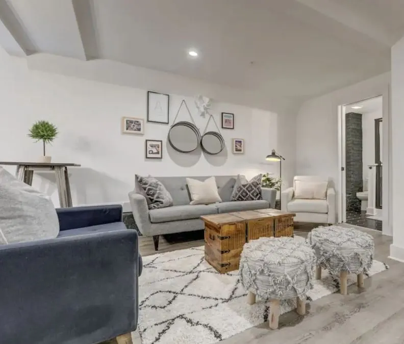 Modern living room with elegant decor, featuring a cozy gray sofa, stylish armchairs, and chic wall art. Perfect for a comfortable and inviting atmosphere.