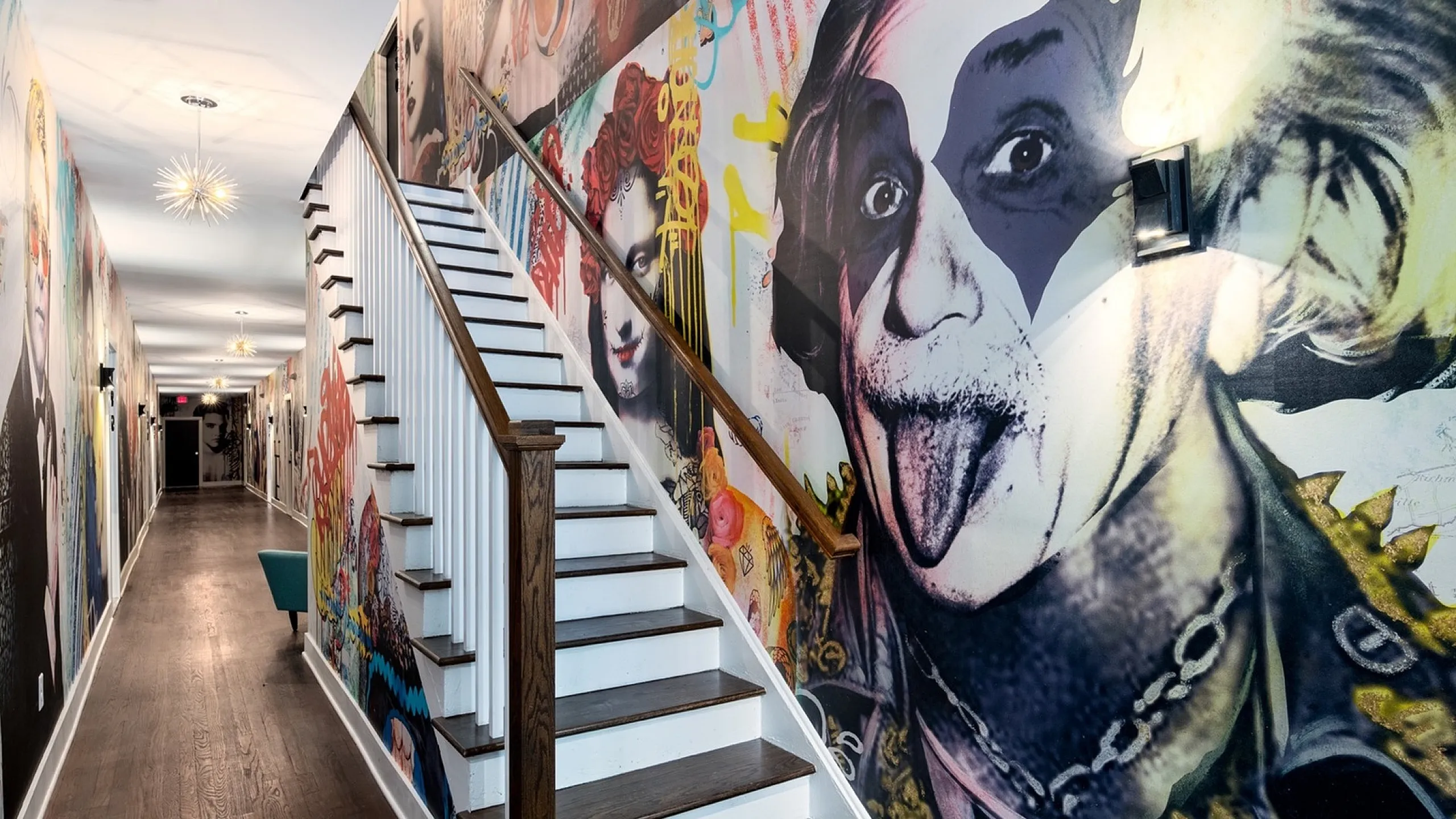 Vibrant hallway with artistic graffiti-themed wall murals and sleek wooden staircase, exuding modern urban flair.
