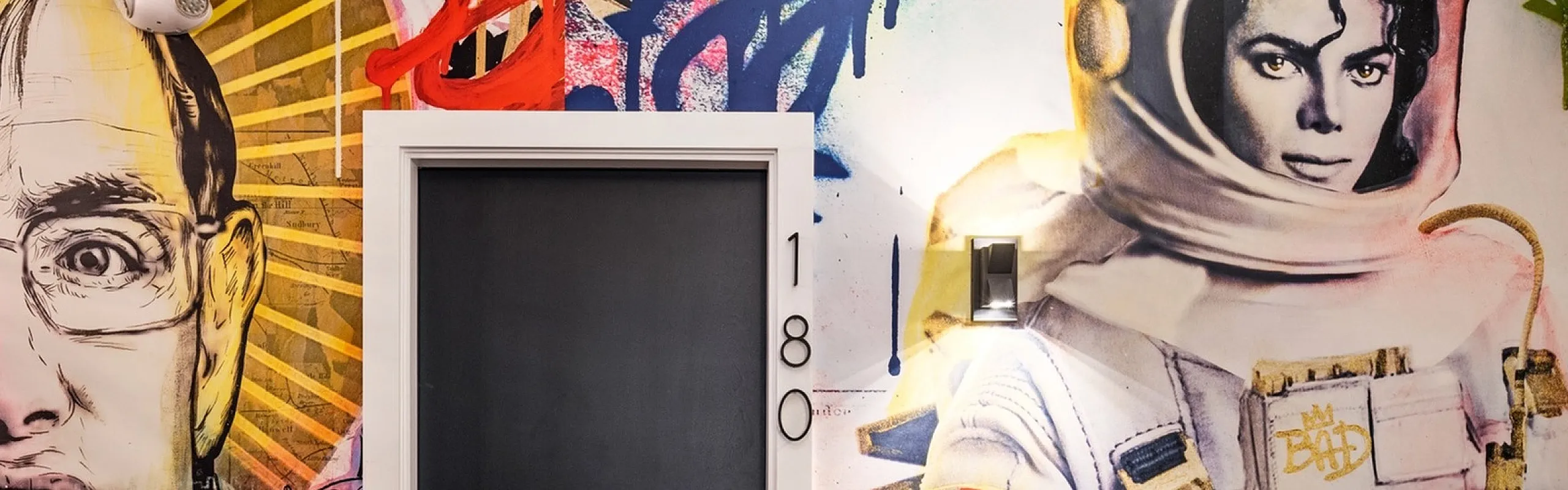 Vibrant apartment entrance showcasing dynamic wall art featuring an astronaut and a stylish modern chair.