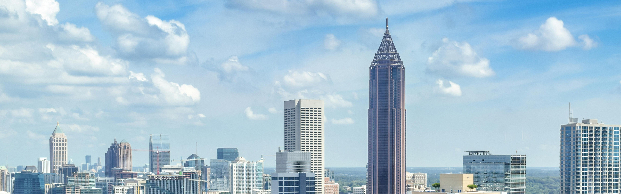 Breathtaking urban skyline view showcasing modern high-rise buildings and lush greenery under a clear blue sky.
