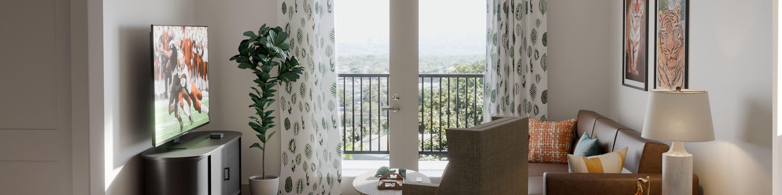 Bright and inviting living room with stylish decor, plush seating, and large TV, opening to a scenic balcony view.