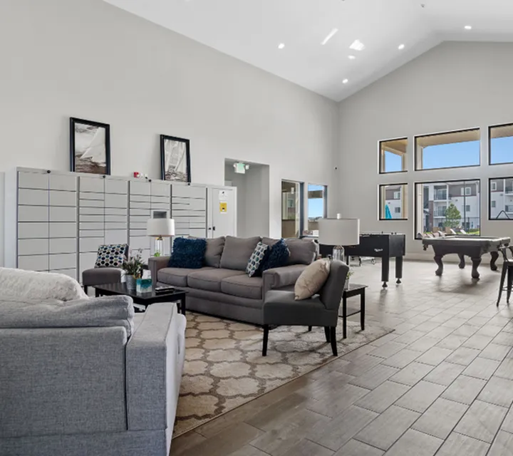 Inviting communal lounge with cozy seating, stylish decor, and panoramic windows overlooking modern architecture.