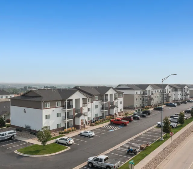 Inviting apartment complex with modern design, ample parking, and well-maintained landscaping, perfect for comfortable living.