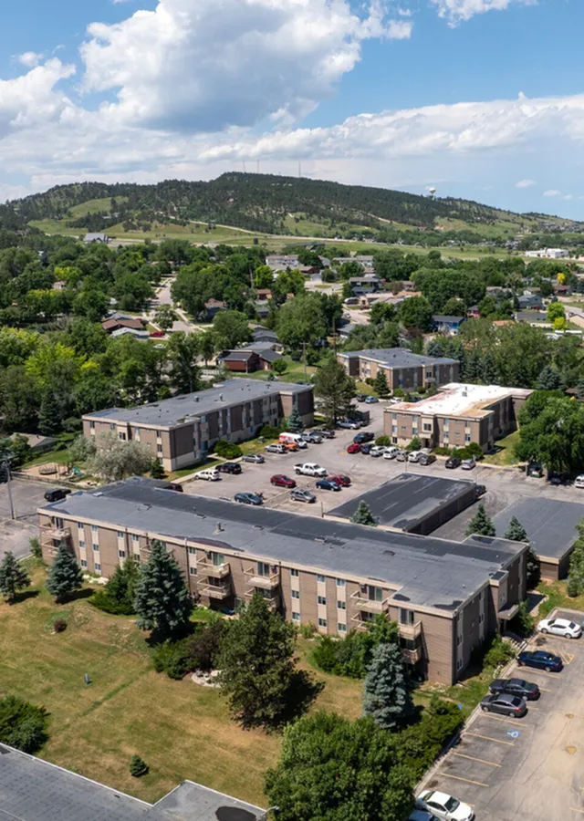 Charming residential apartments surrounded by lush greenery and scenic hills, featuring ample parking and a vibrant community atmosphere.