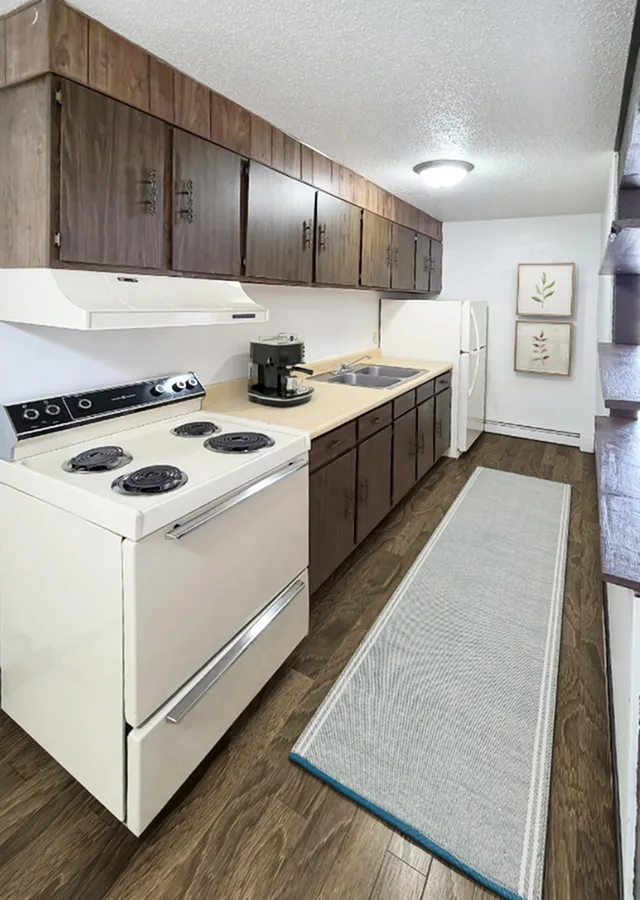 Charming kitchen with dark wood cabinets, modern appliances, and a cozy ambiance featuring elegant decor.