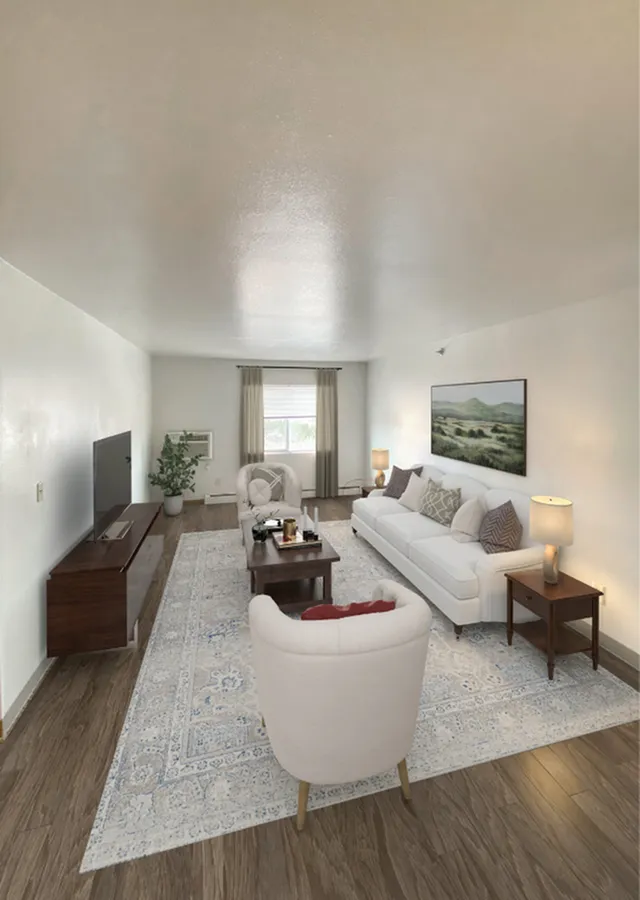 Inviting living room with elegant decor featuring a plush white sofa, accent chairs, and a sleek entertainment center. Natural light fills the space, highlighting the stylish rug and hardwood floors.