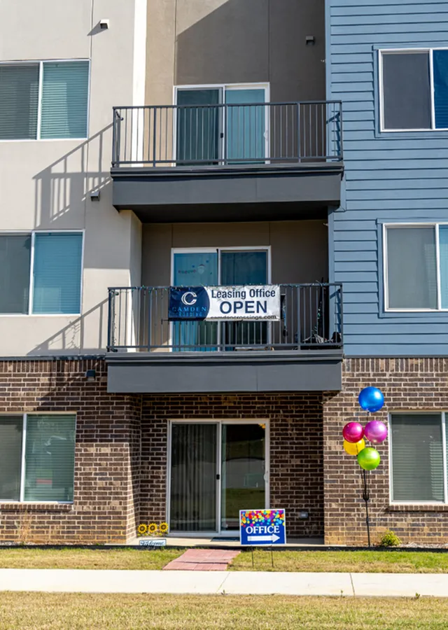 Inviting leasing office entrance with colorful balloons and modern balcony, signaling a welcoming community atmosphere.