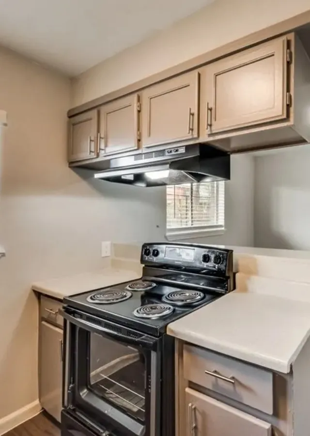 Charming kitchen with sleek appliances, ample cabinet storage, and natural light from a nearby window.