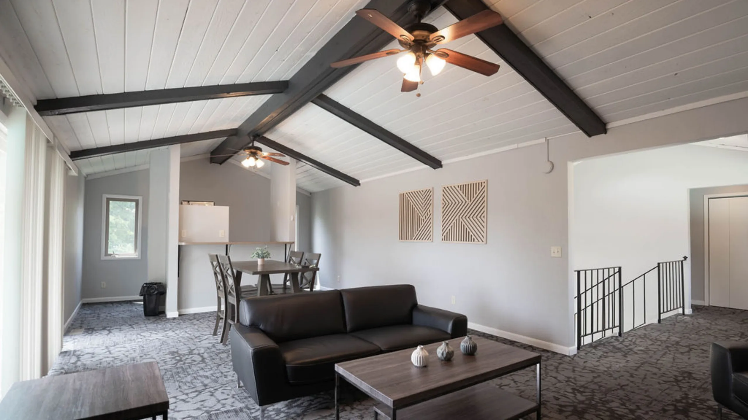 Chic living room with vaulted ceilings, exposed beams, and modern furniture exuding contemporary elegance.