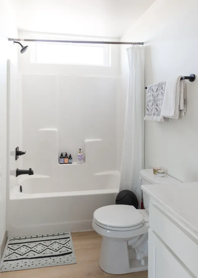Bright and modern bathroom featuring a pristine white shower, sleek faucet fixtures, and elegant decor.