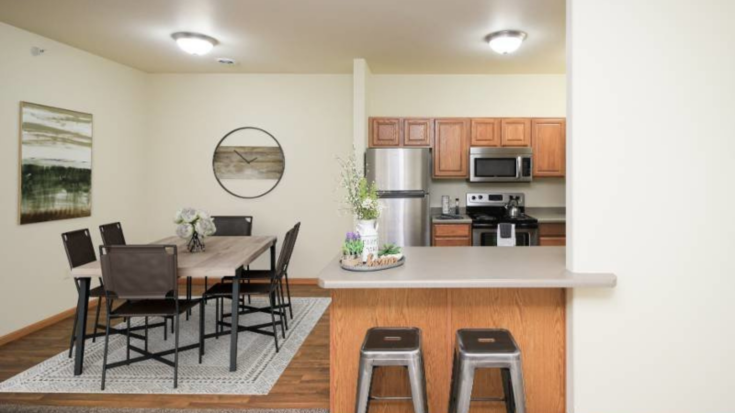Chic open-plan kitchen and dining area with modern appliances, wooden cabinetry, and a stylish dining set.