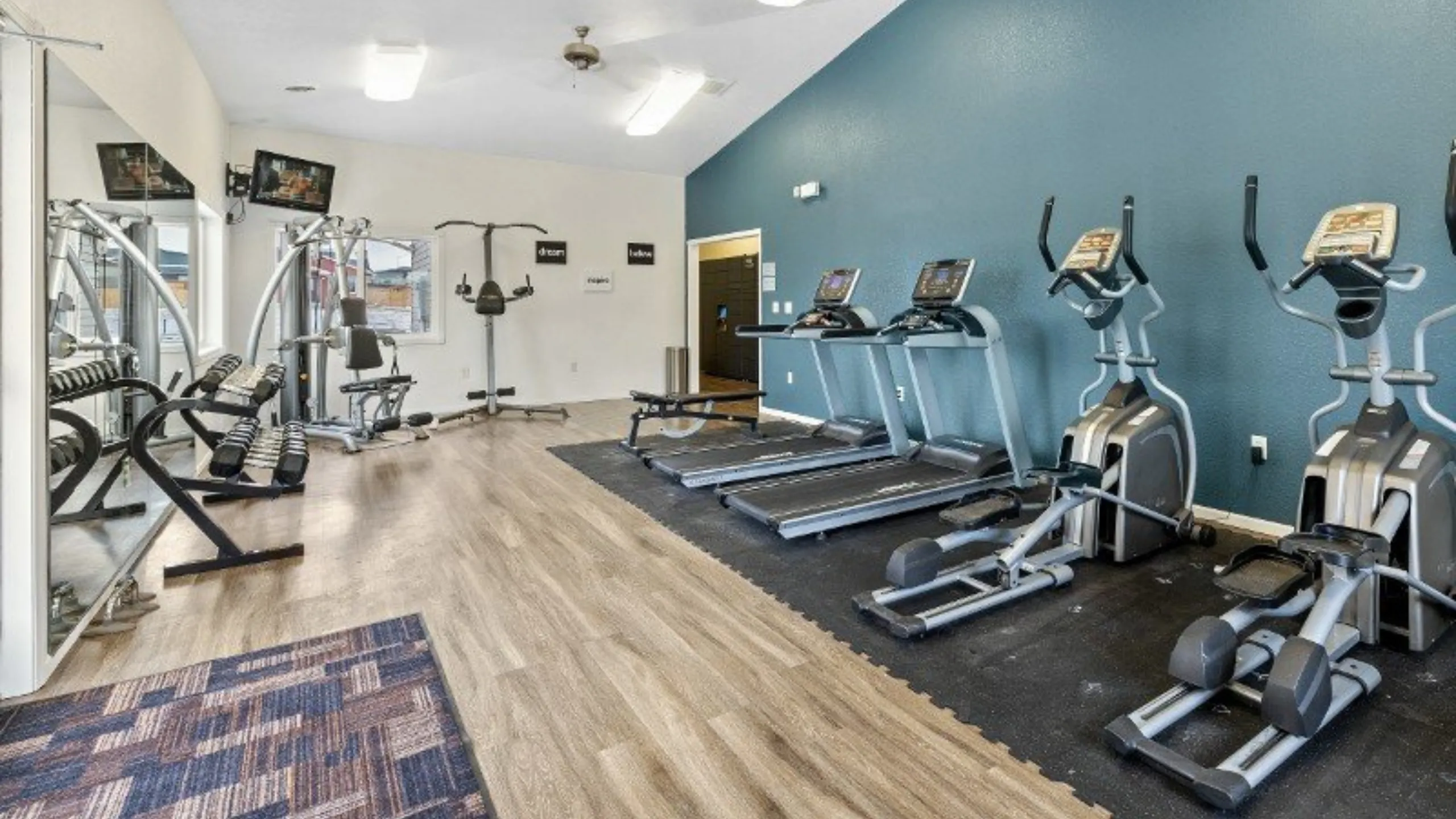Modern fitness center with state-of-the-art exercise equipment, including treadmills and weights, in a stylish, well-lit space.