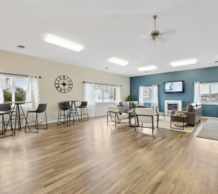 Elegant open-concept living room with wooden flooring, modern seating area, large windows, and contemporary decor.