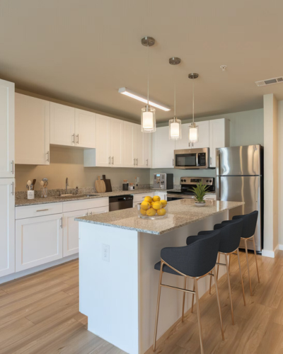 Modern kitchen with sleek white cabinets, stainless steel appliances, and a stylish island with pendant lighting.
