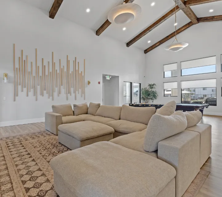 Spacious living room with vaulted ceilings, chic sectional sofa, and modern decor, perfect for relaxation and entertainment.