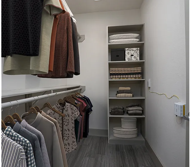 Spacious walk-in closet with stylish shelving and neatly organized clothing.