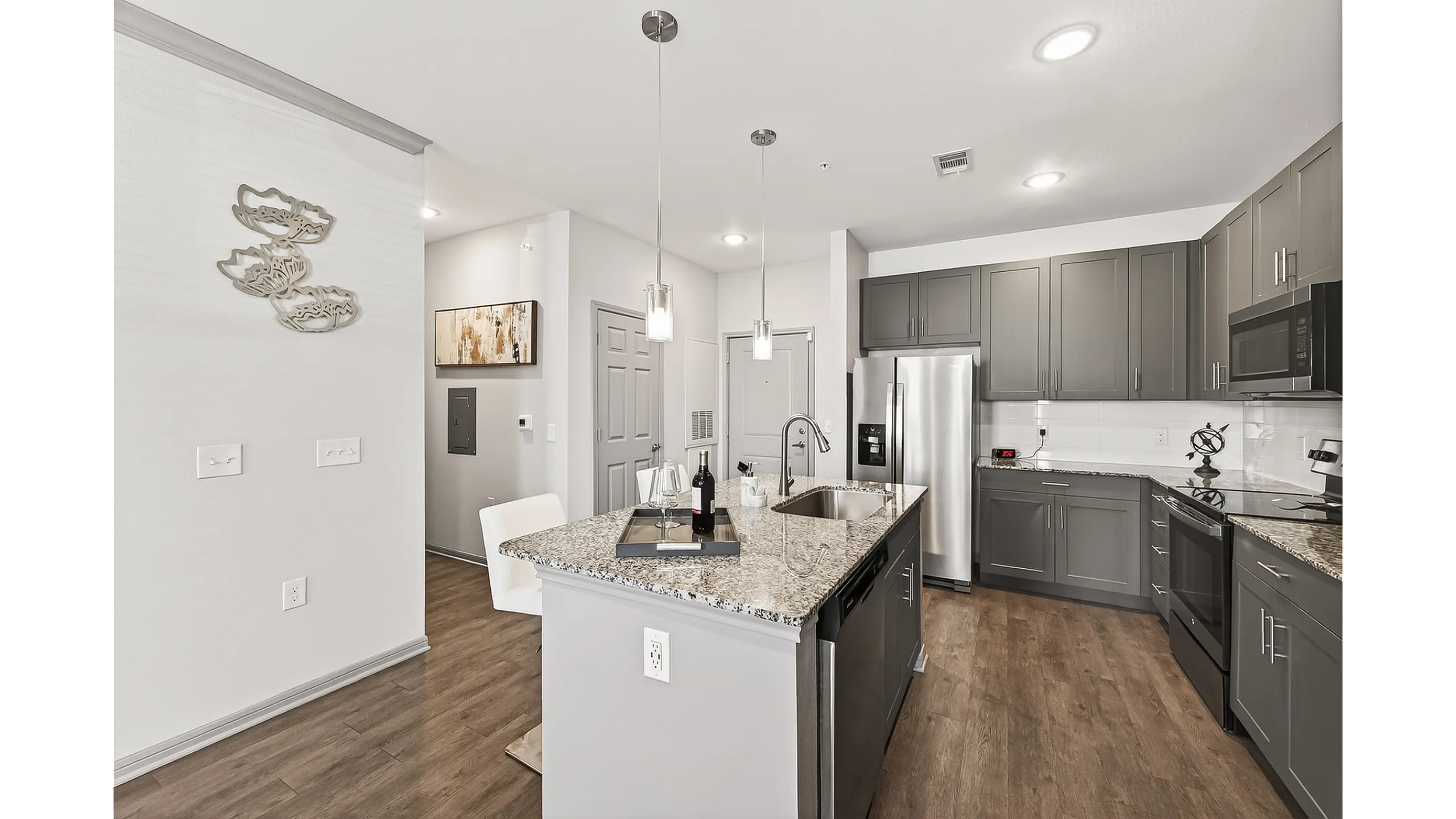 Modern kitchen with sleek dark cabinetry, granite countertops, and stainless steel appliances, offering an inviting and functional cooking space.