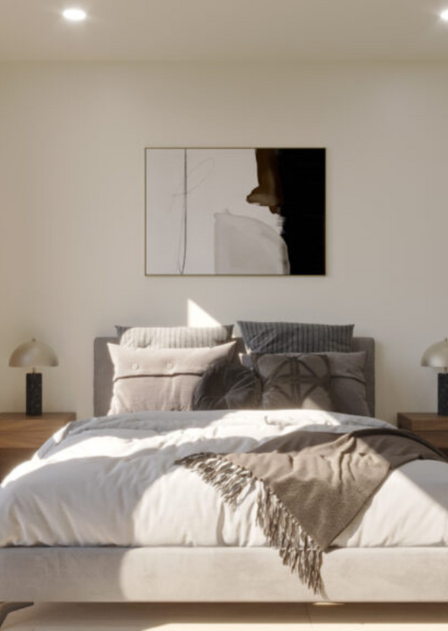 Elegant bedroom with cozy bedding, modern lamps, and abstract artwork.
